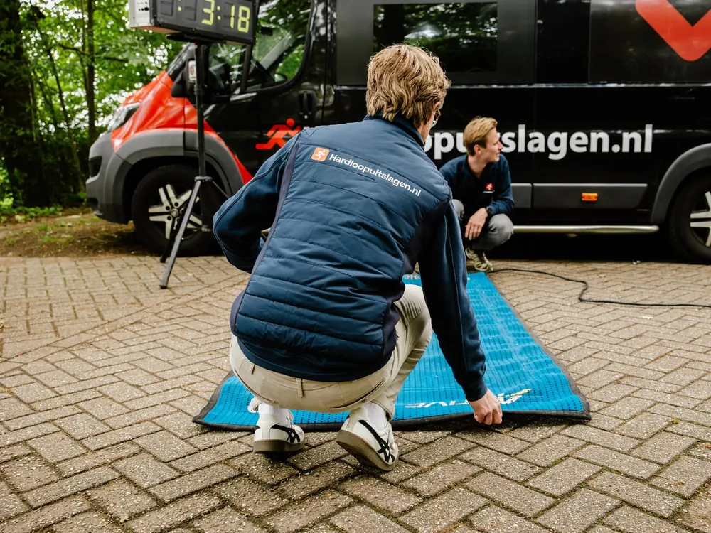 Tijdwaarnemers leggen de IPICO mat klaar bij de Hardloopuitslagen.nl bus