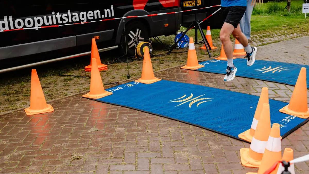 Loper passeert de tijdwaarnemingsmat bij de finish